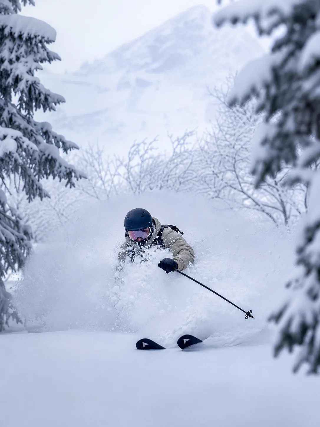 Skier carving deep powder through a snow-laden forest in Japan.